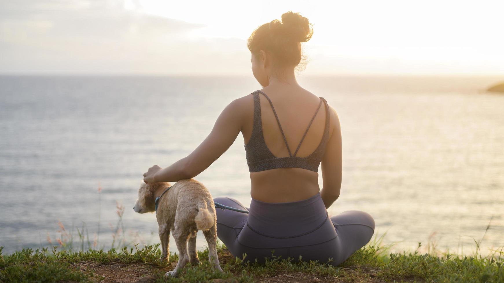 Young Beautiful woman with her dog enjoying and relaxing on the seaside during sunset,  Summer, vacation, holidays, Lifestyles concept. photo