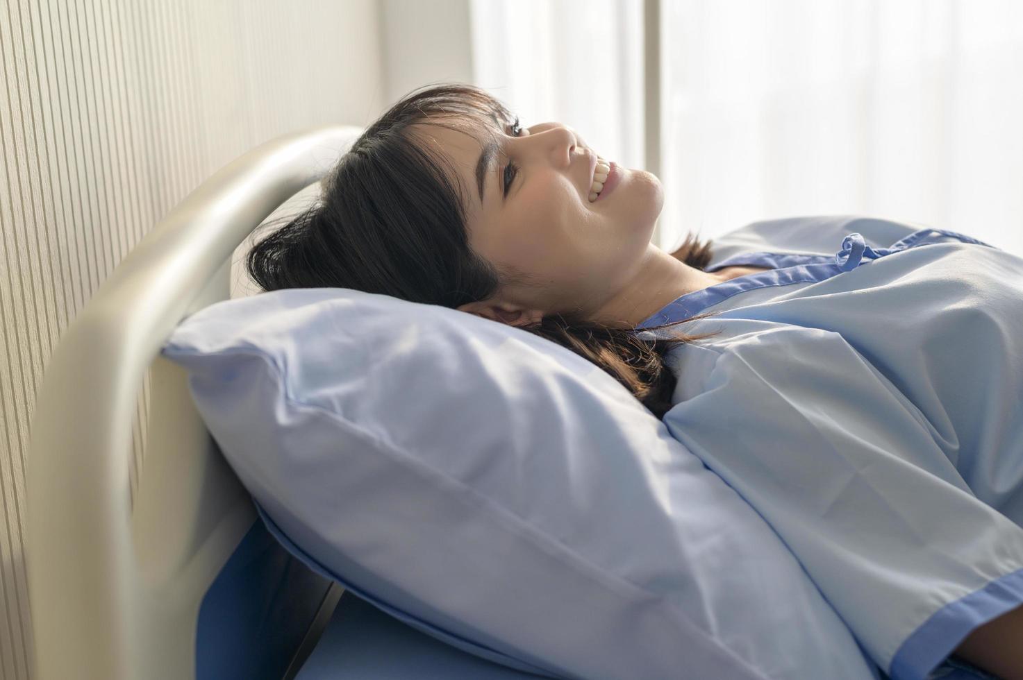 Hopeful and happy young patient woman in hospital, healthcare and medical concept photo