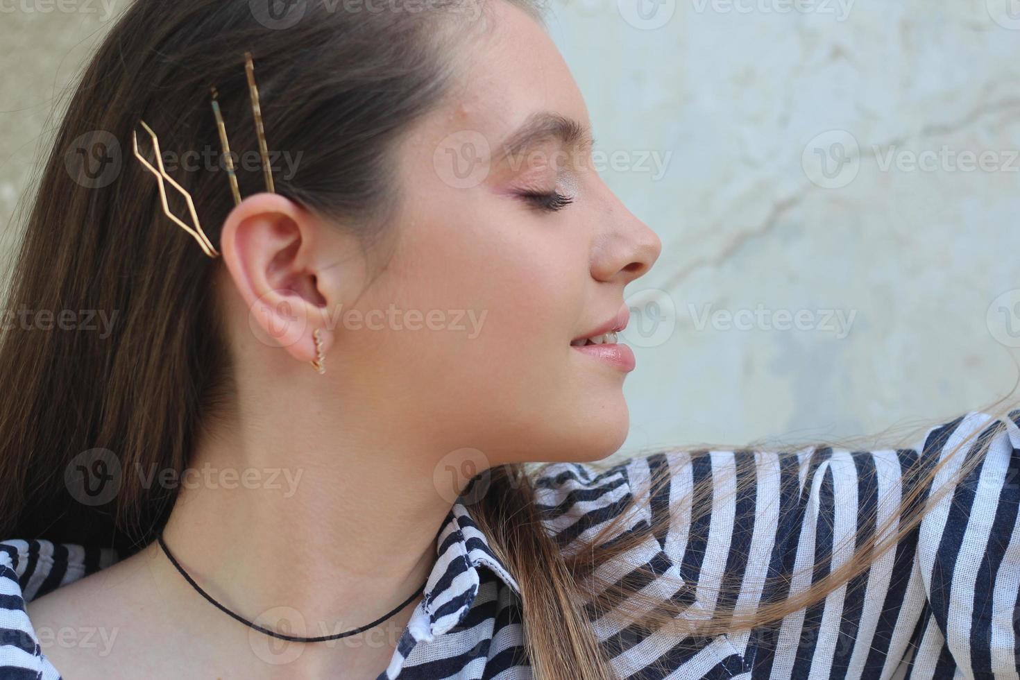 portrait of a young woman resting and enjoying the sun at sunset by the sea, a girl in a sailor shirt, striped shirt photo