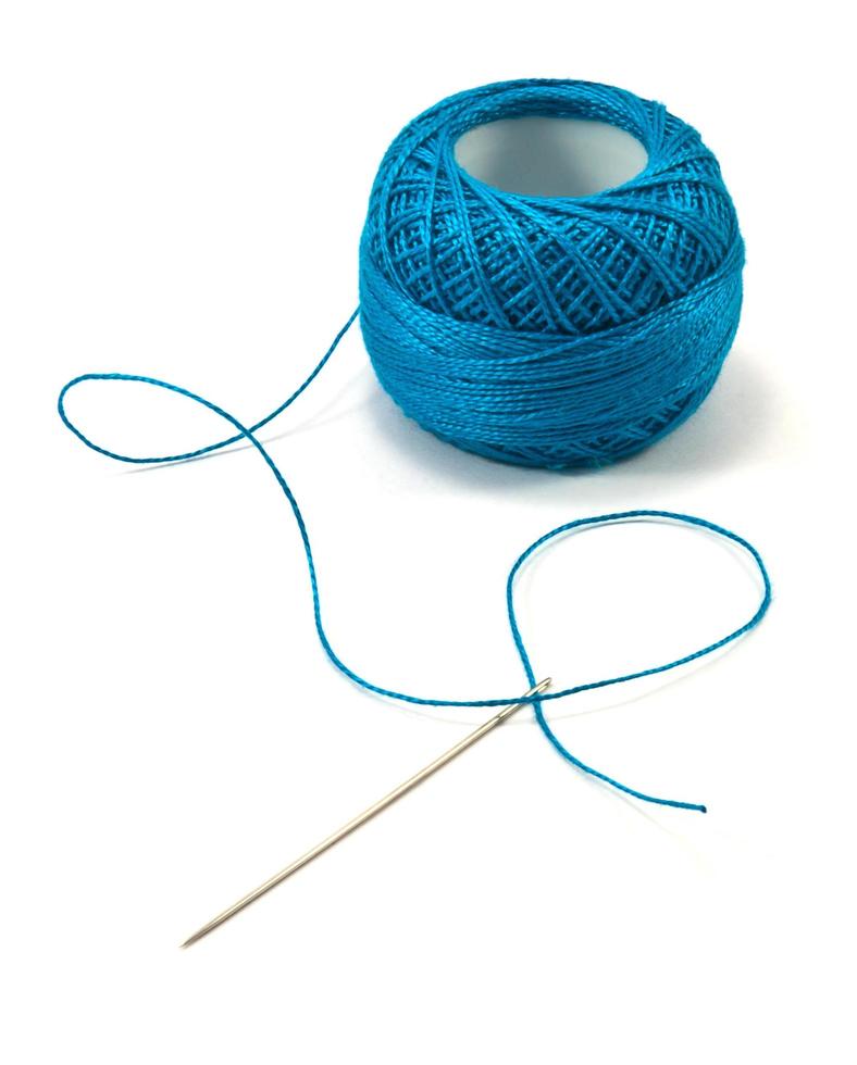 Blue thread ball and needle thread isolated on white photo