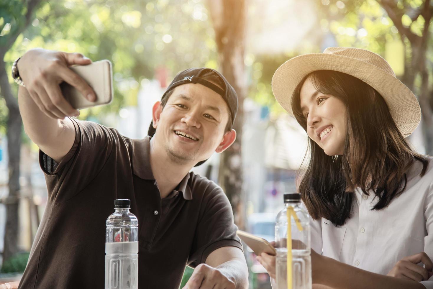 Asian couple enjoy traveling sitting at coffee shop - happy young people on vacation concept photo