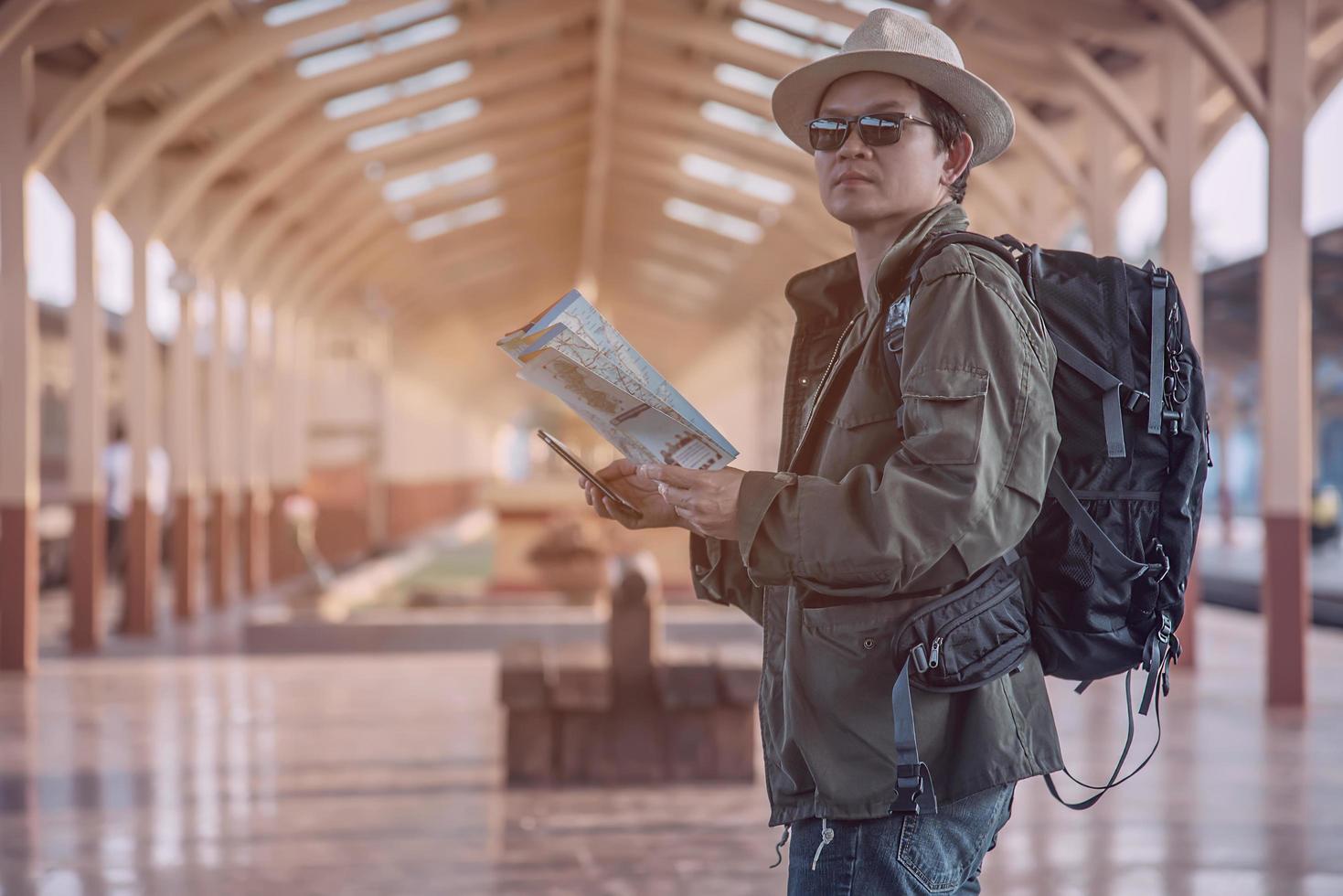 hombre de viaje espera el tren en la plataforma - personas actividades de estilo de vida de vacaciones en el concepto de transporte de la estación de tren foto