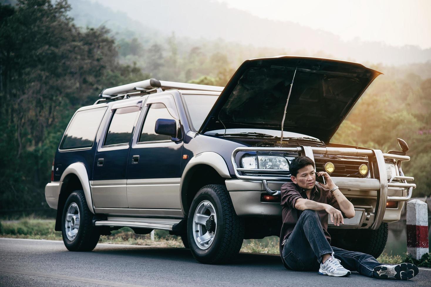 Man try to fix a car engine problem on a local road Chiang mai Thailand - people with car problem transportation concept photo