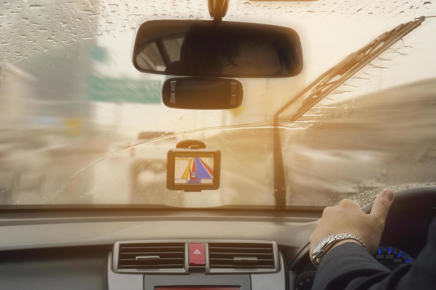 Business man is driving a car in raining day with moving wiper blades photo