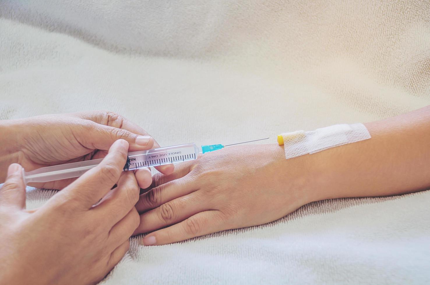 Doctor holding syringe in hand injects to a patient arm photo