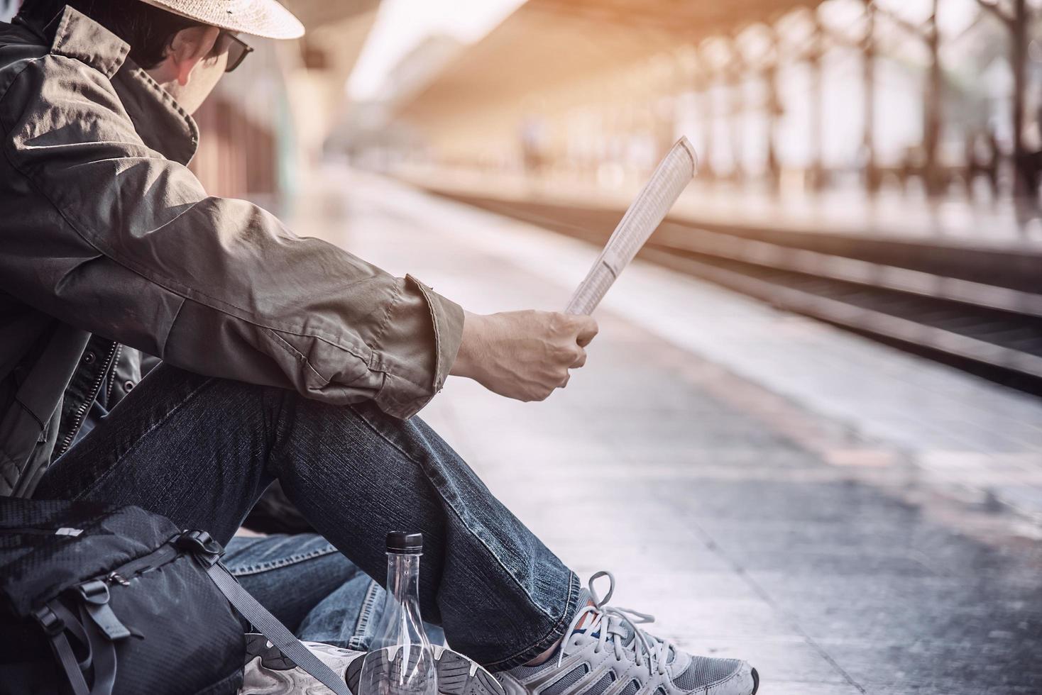 hombre de viaje espera el tren en la plataforma - personas actividades de estilo de vida de vacaciones en el concepto de transporte de la estación de tren foto