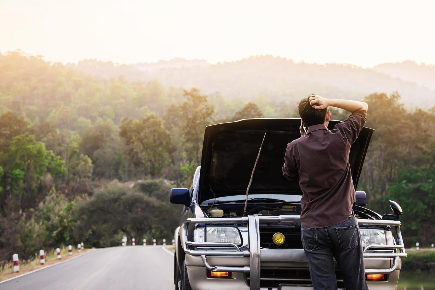 Man try to fix a car engine problem on a local road Chiang mai Thailand - people with car problem transportation concept photo