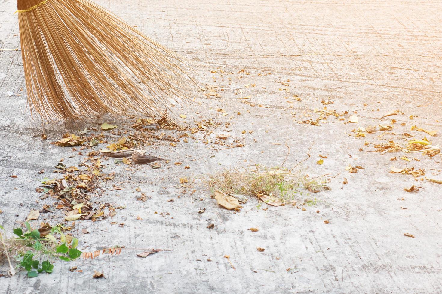 Man cleaning outdoor road using bloom made from dry coconut leave product - local people lifestyle concept in Thailand photo