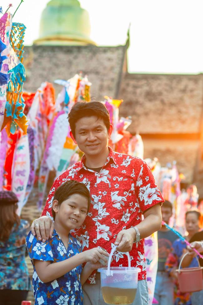 la familia tailandesa participa en una antigua actividad tradicional en un templo durante el festival songkran en chiang mai, el norte de tailandia, un evento muy famoso de tailandia foto