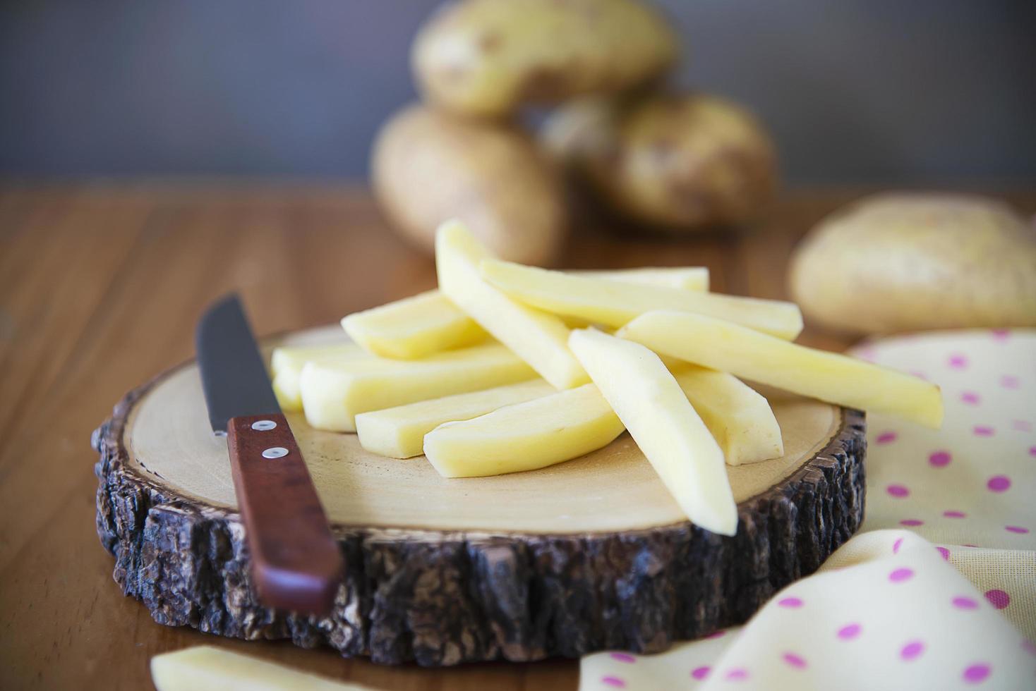 palo de patata en rodajas listo para hacer patatas fritas - concepto tradicional de preparación de alimentos foto