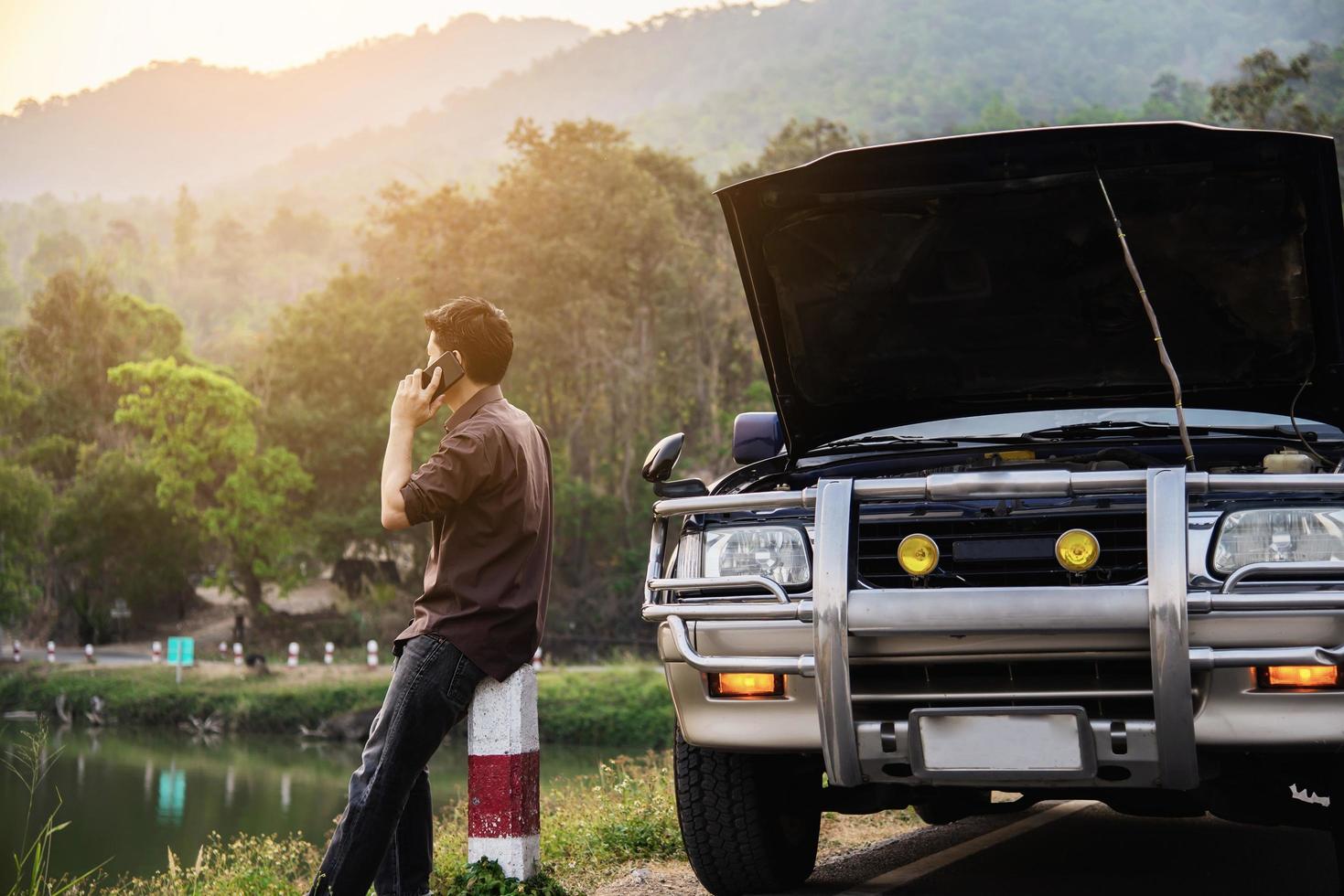 Man try to fix a car engine problem on a local road Chiang mai Thailand - people with car problem transportation concept photo