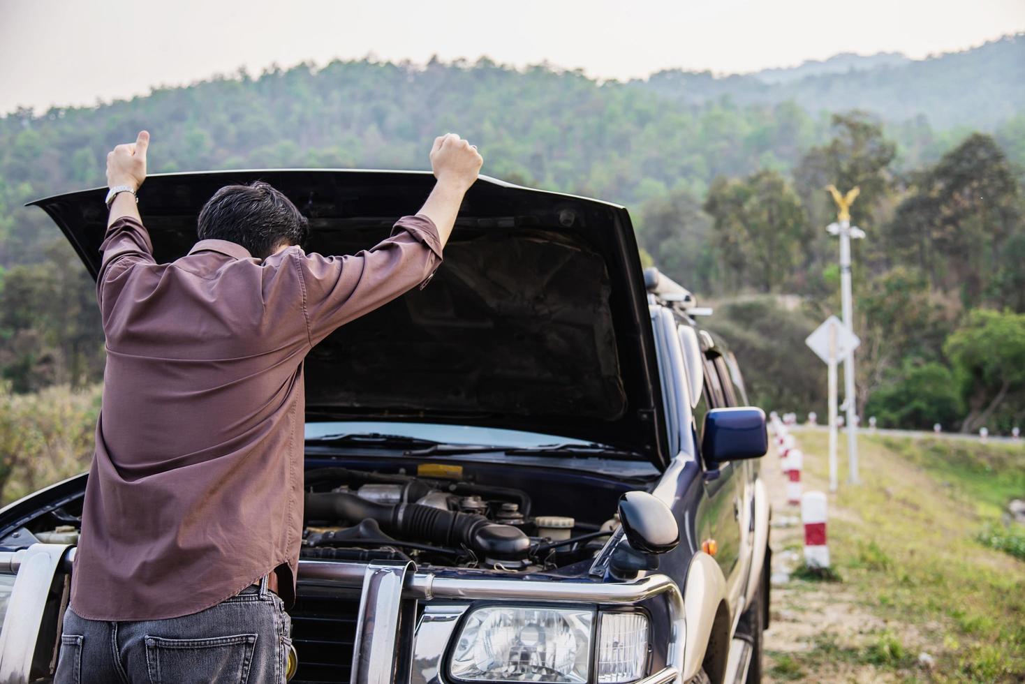 Man try to fix a car engine problem on a local road Chiang mai Thailand - people with car problem transportation concept photo