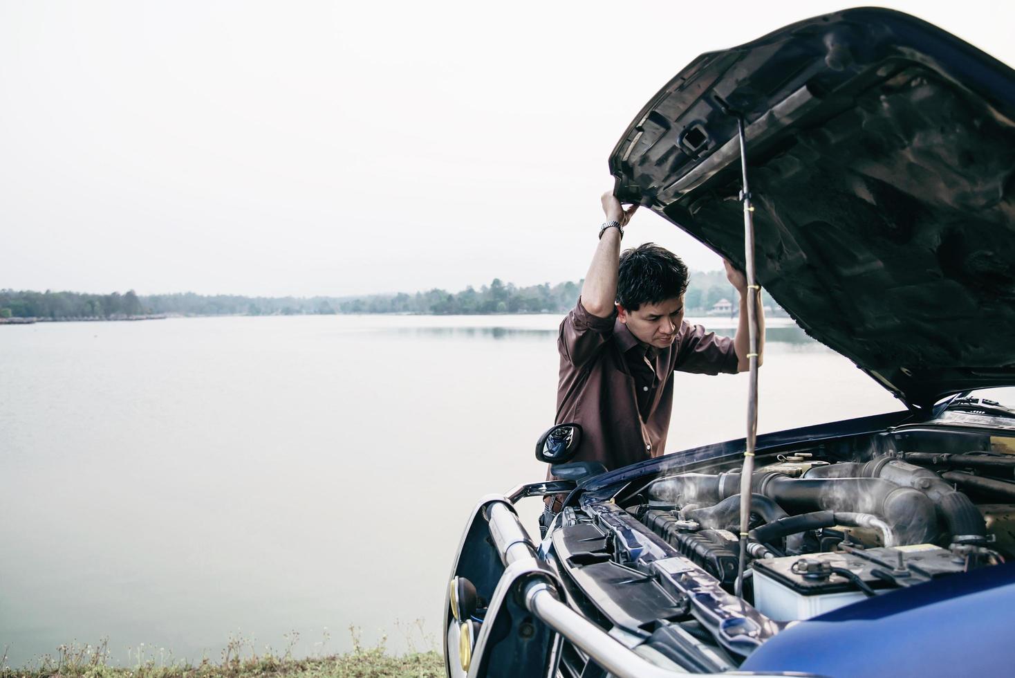 Man try to fix a car engine problem on a local road Chiang mai Thailand - people with car problem transportation concept photo