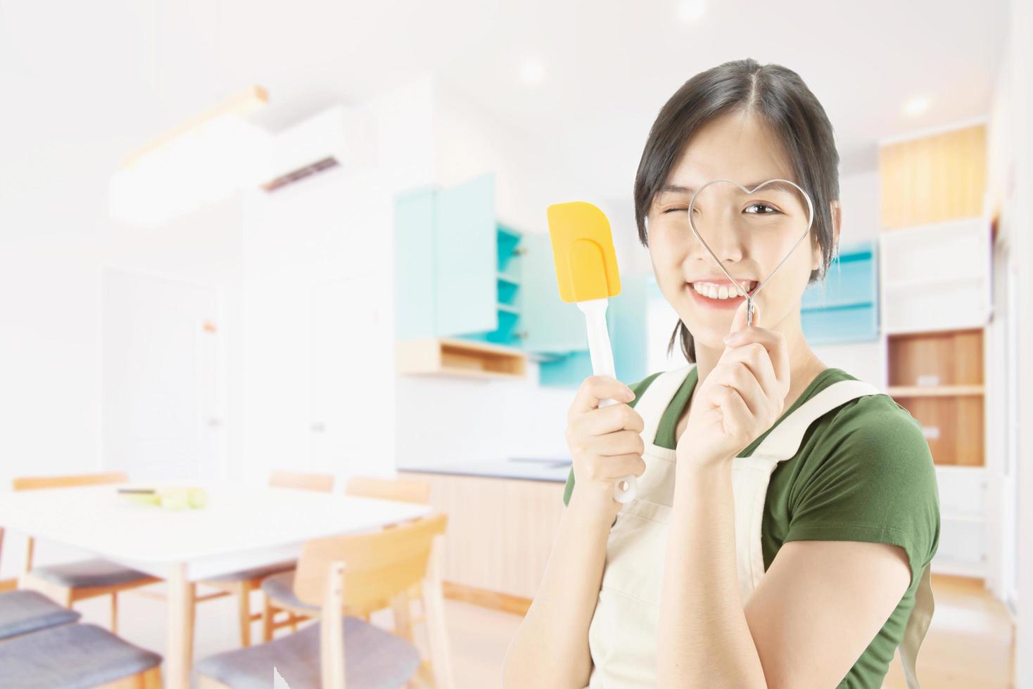 Happy lady holding kichen stuff over copy space background - people home made food preparation concept photo