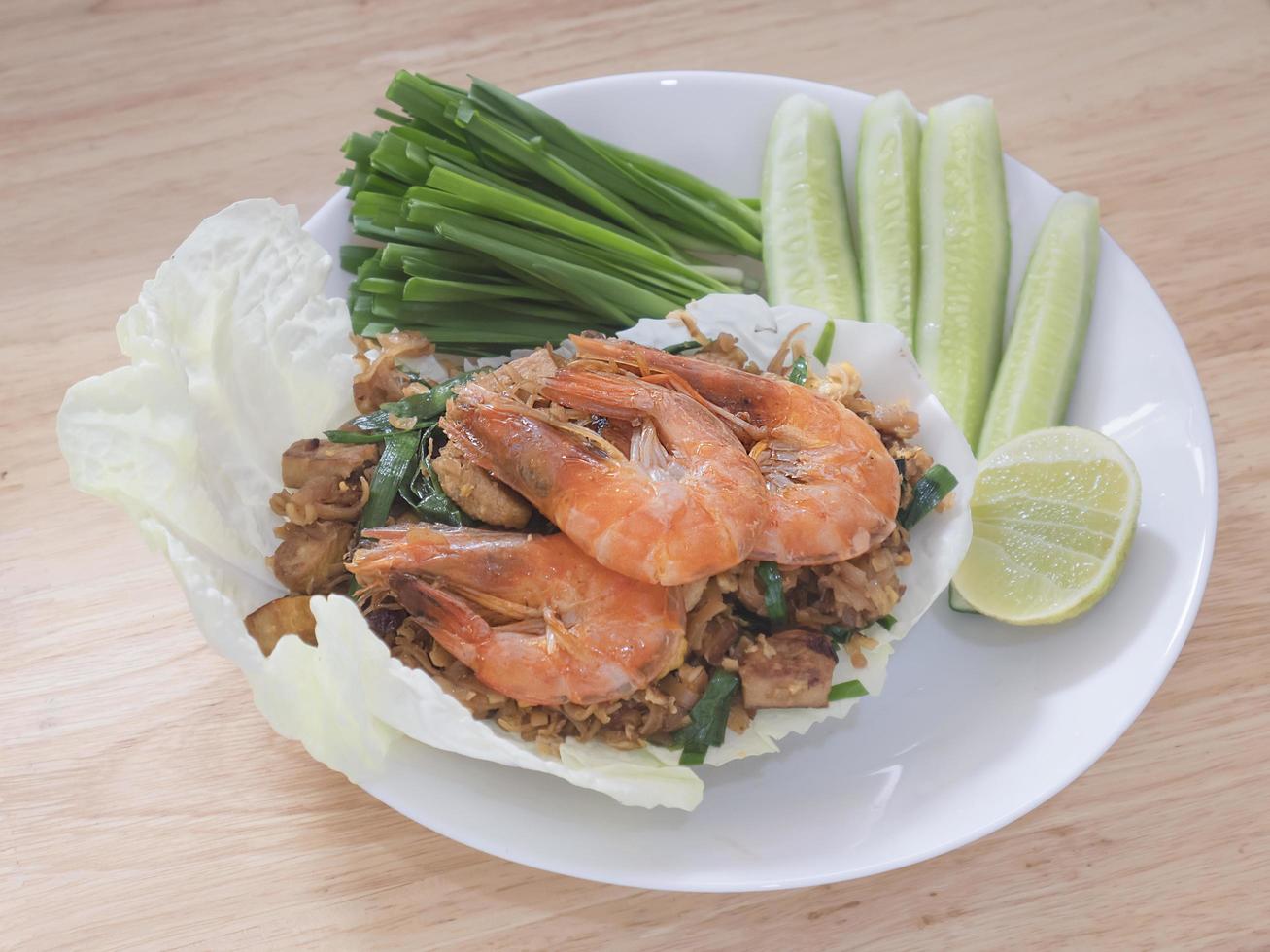 Fried noodle Thai style with prawns and fresh vegetable called- famous Thai style food recipe concept photo