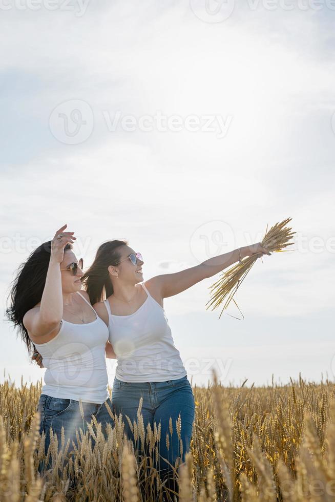 dos amigas sonrientes en el campo de trigo foto