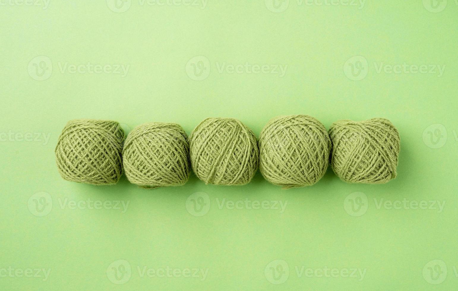 bright green yarn wool in a raw on bright background, top view flat lay photo