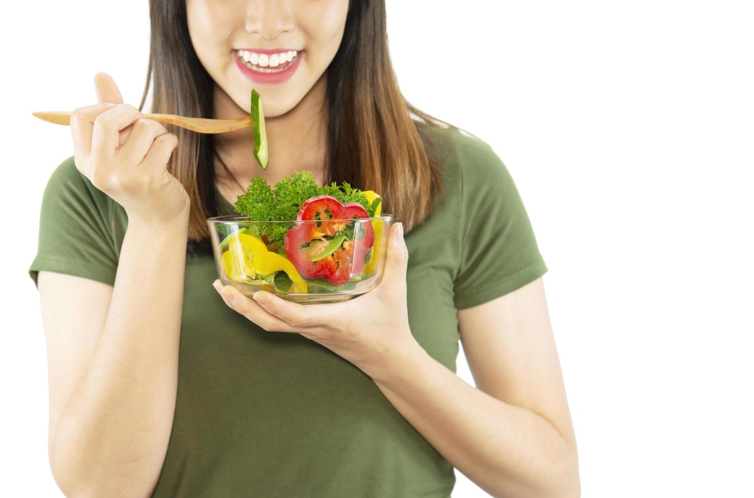 Happy lady enjoy eating vegetable salad over white copy space background - people with organic healthy food concept photo