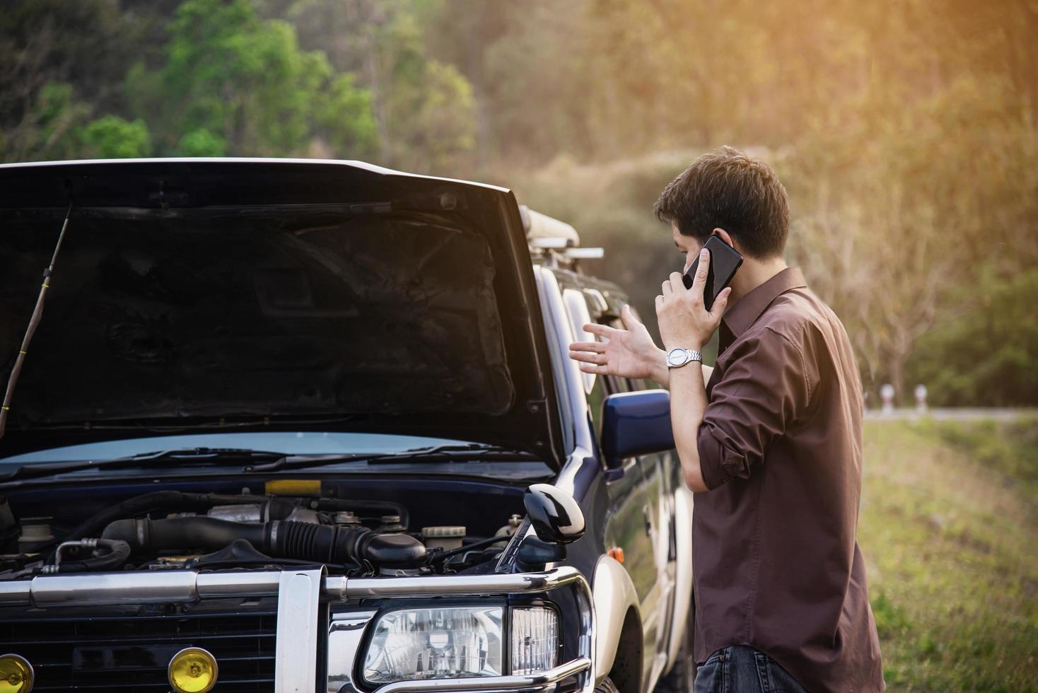 Man try to fix a car engine problem on a local road Chiang mai Thailand - people with car problem transportation concept photo