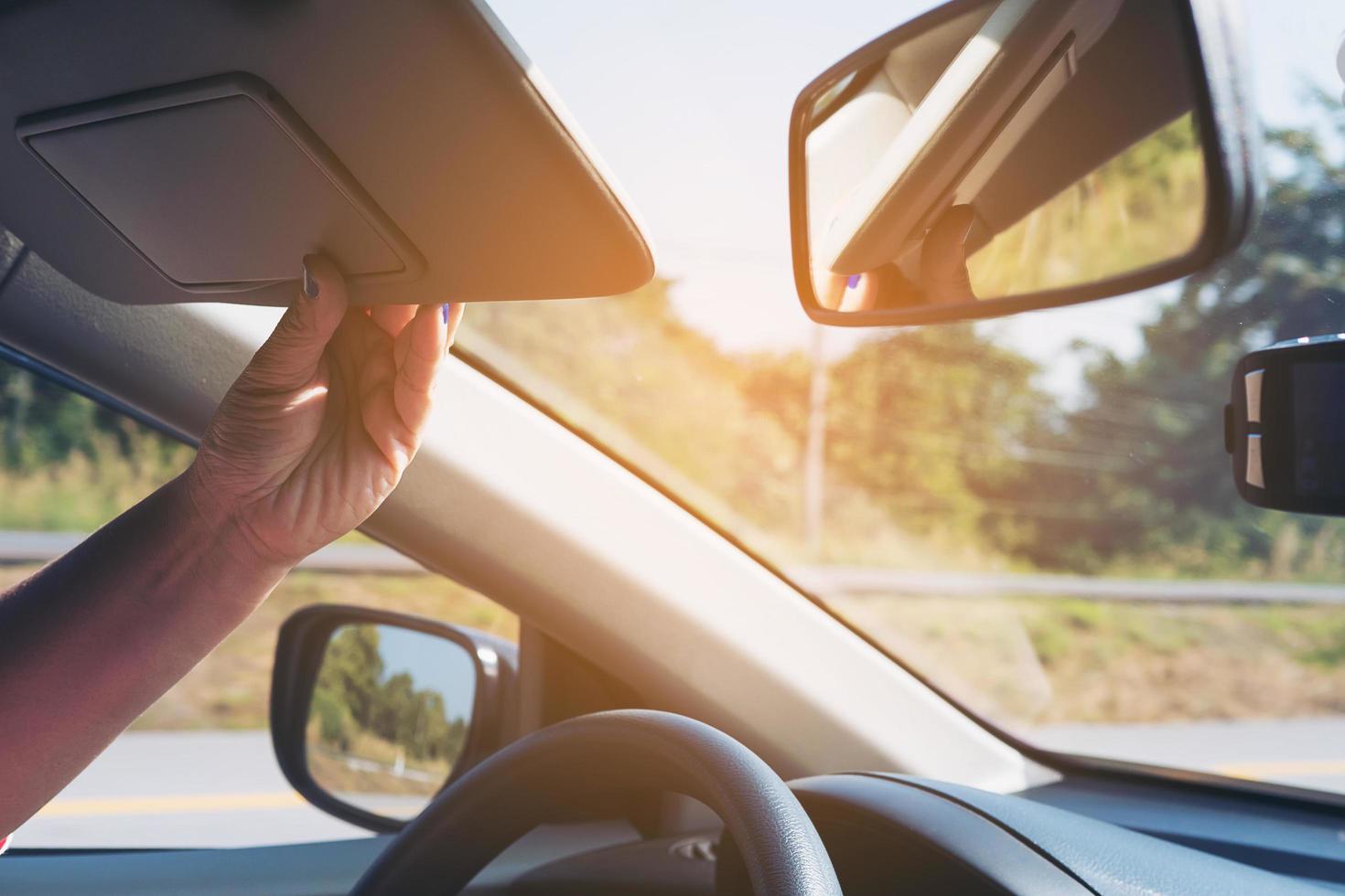 Lady adjust sun visor while driving car on highway road - interior car using concept photo