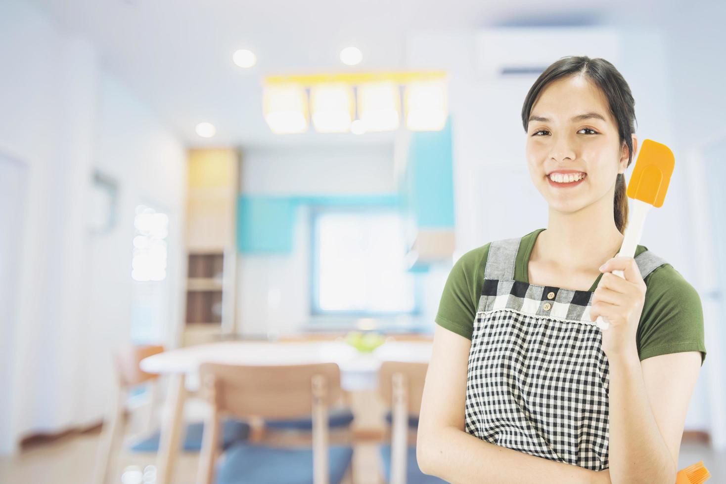 Happy lady holding kichen stuff over copy space background - people home made food preparation concept photo