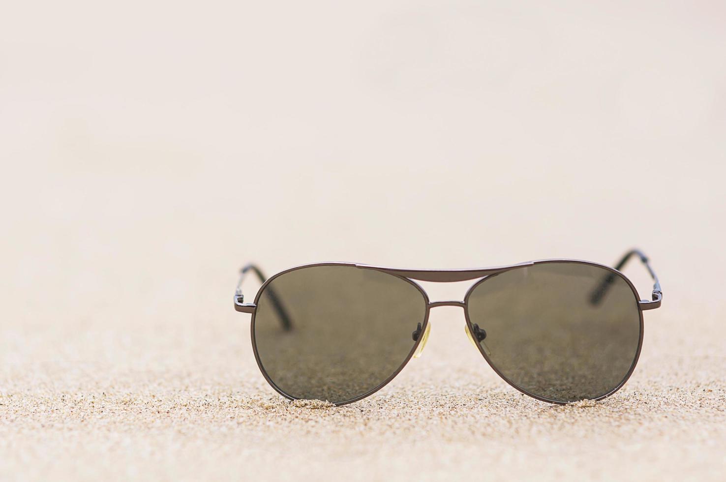 Sun glasses on fine sand beach photo