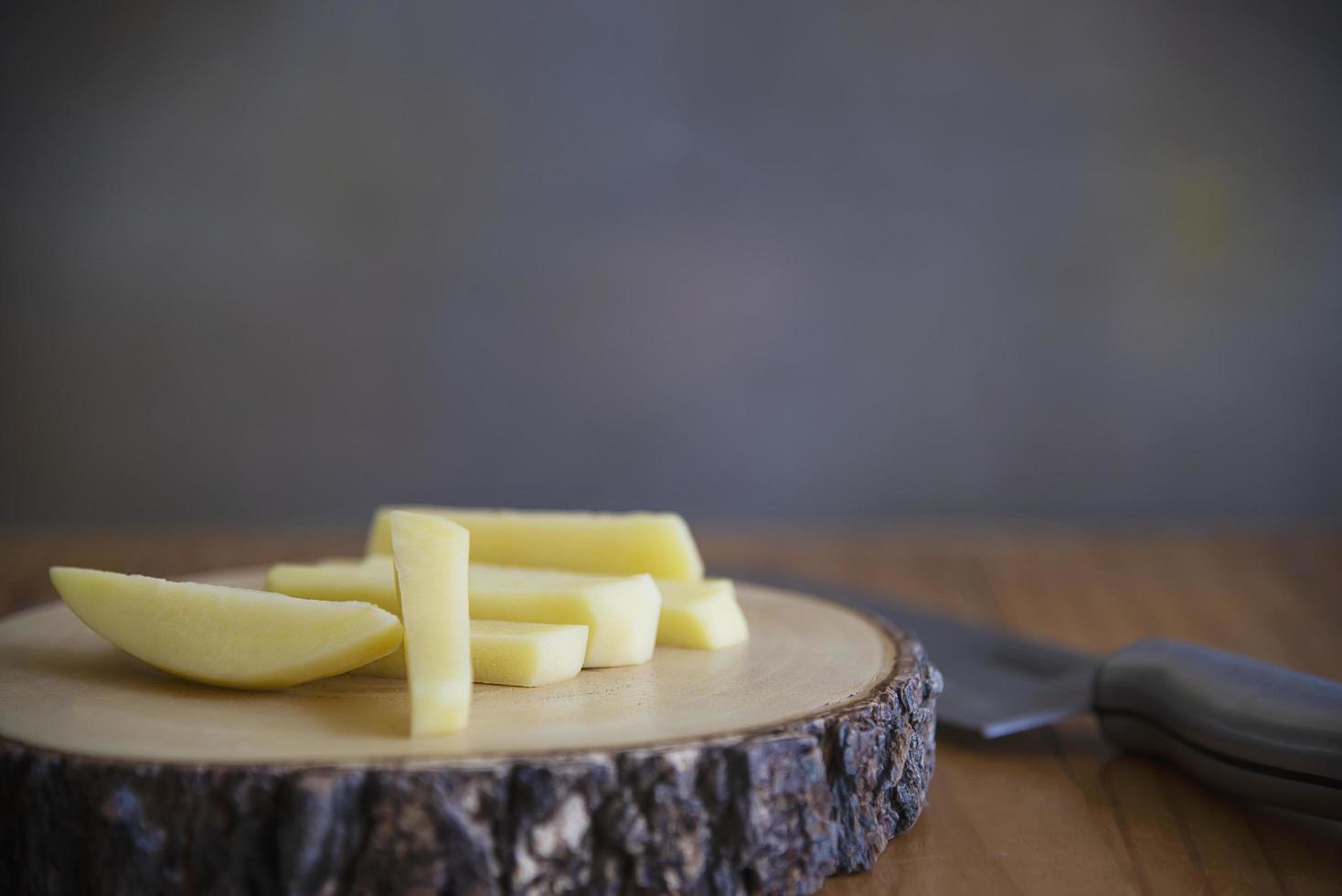 palo de patata en rodajas listo para hacer patatas fritas - concepto tradicional de preparación de alimentos foto