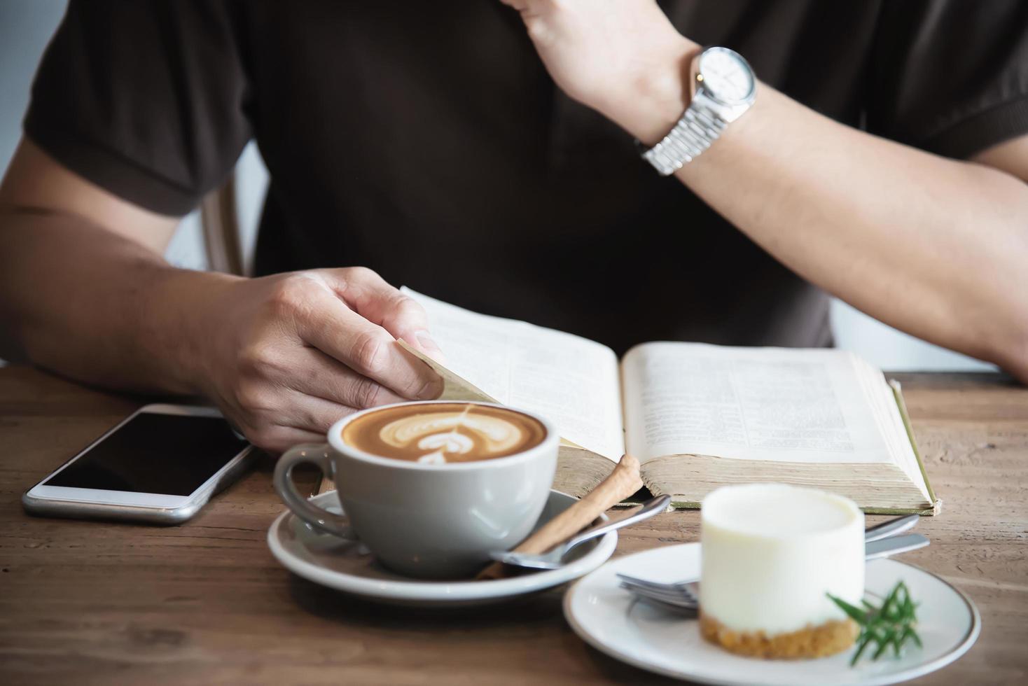 Relax Asian man drink coffee and read book in a modern style coffee shop - people with coffee cup easy lifestyle concept photo