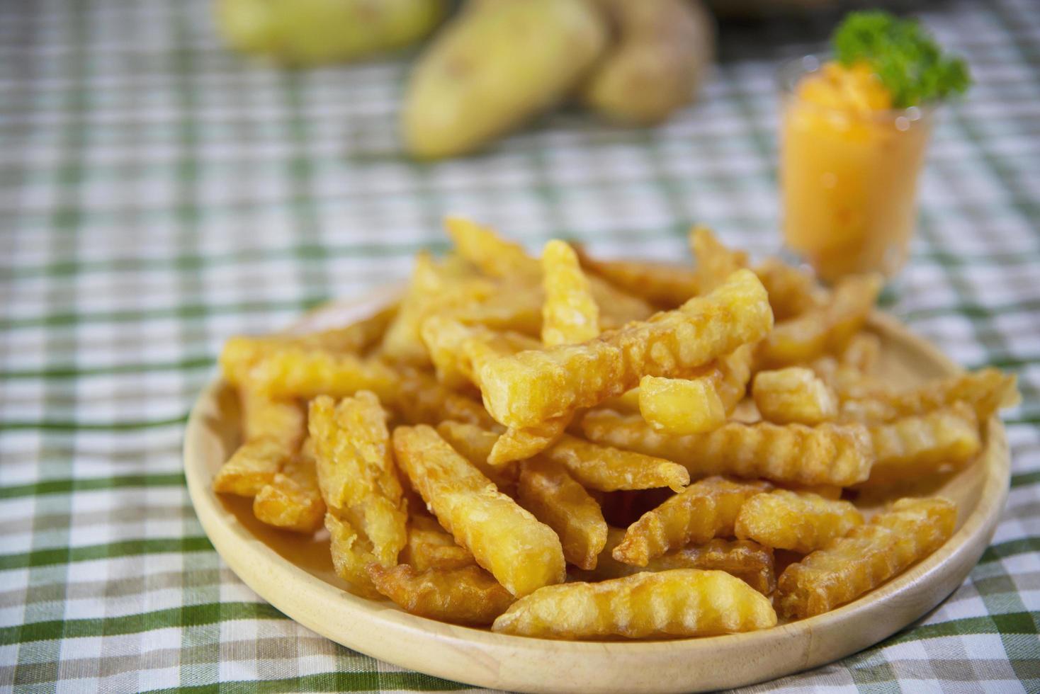 Delicious fried potato on wooden plate with dipped sauce - traditional fast food concept photo