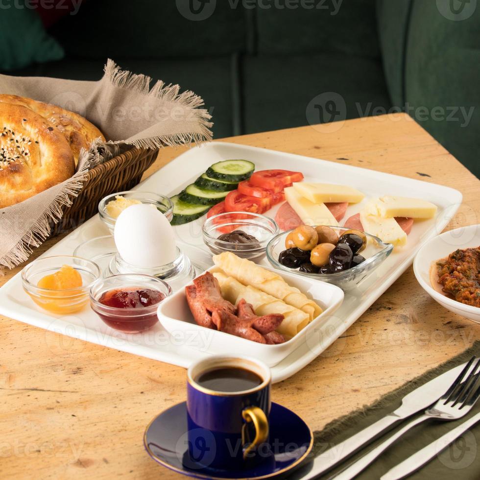 A closeup shot of a breakfast white plate and a cup of coffee on a wooden table photo