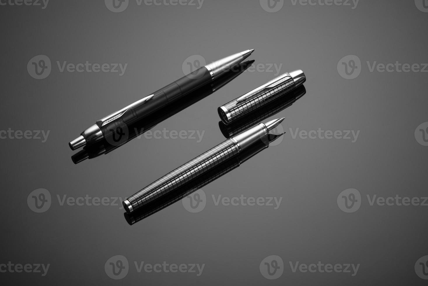 A closeup of fashionable ink pens on a black background photo