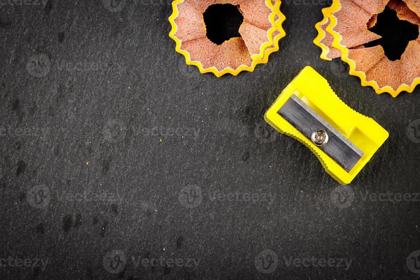 Yellow shavings pencil and yellow pencil sharpener on black background. Horizontal image. photo