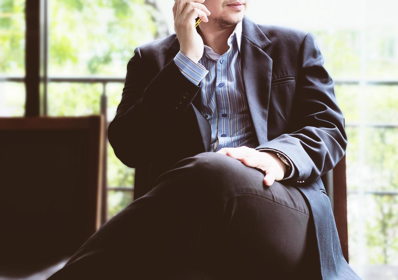 Business man using mobile phone in coffee shop photo