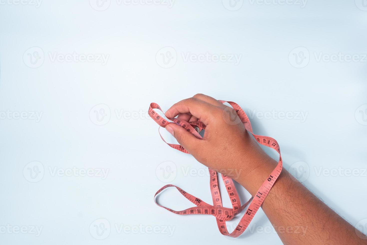 an asian man's hand is measuring using a tape measure, which tailors usually use, isolated on a white background photo