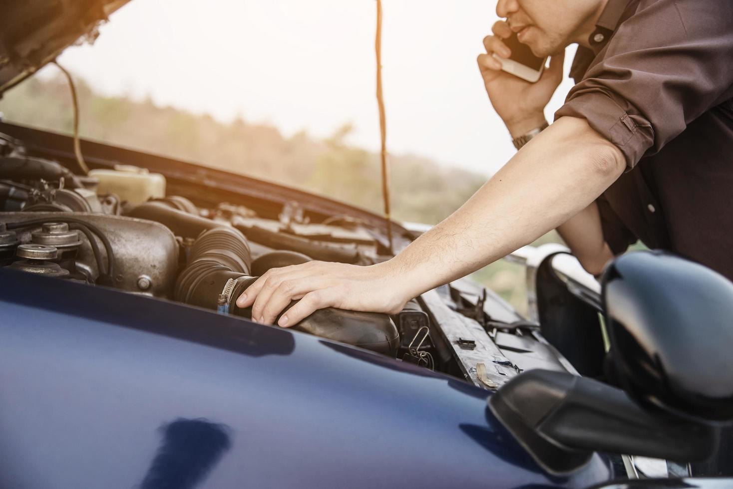 Man try to fix a car engine problem on a local road Chiang mai Thailand - people with car problem transportation concept photo