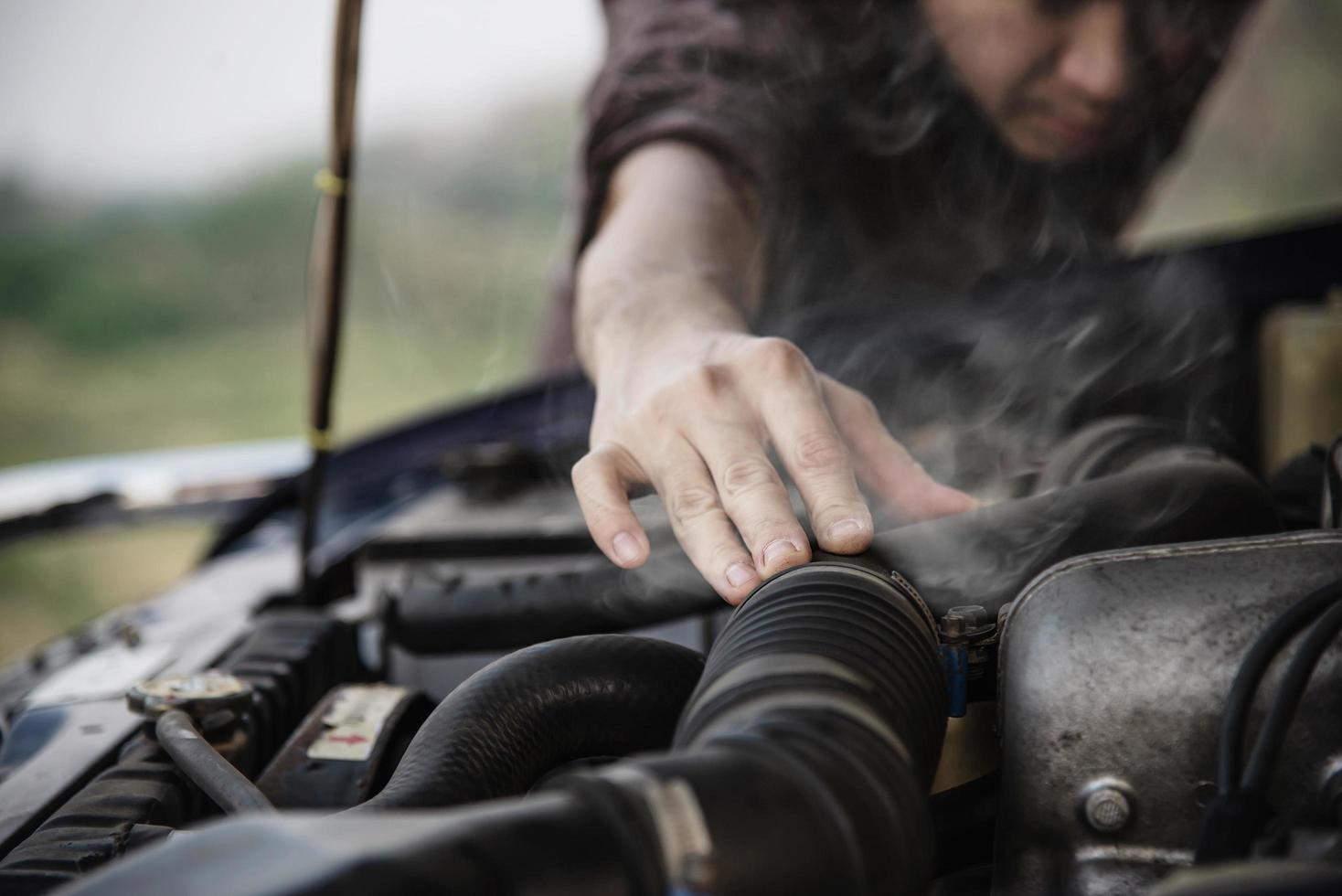 Man try to fix a car engine problem on a local road Chiang mai Thailand - people with car problem transportation concept photo