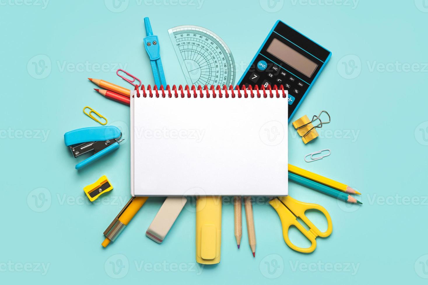 Top view of spiral notepad and school supplies with space for text. Back to school concept photo