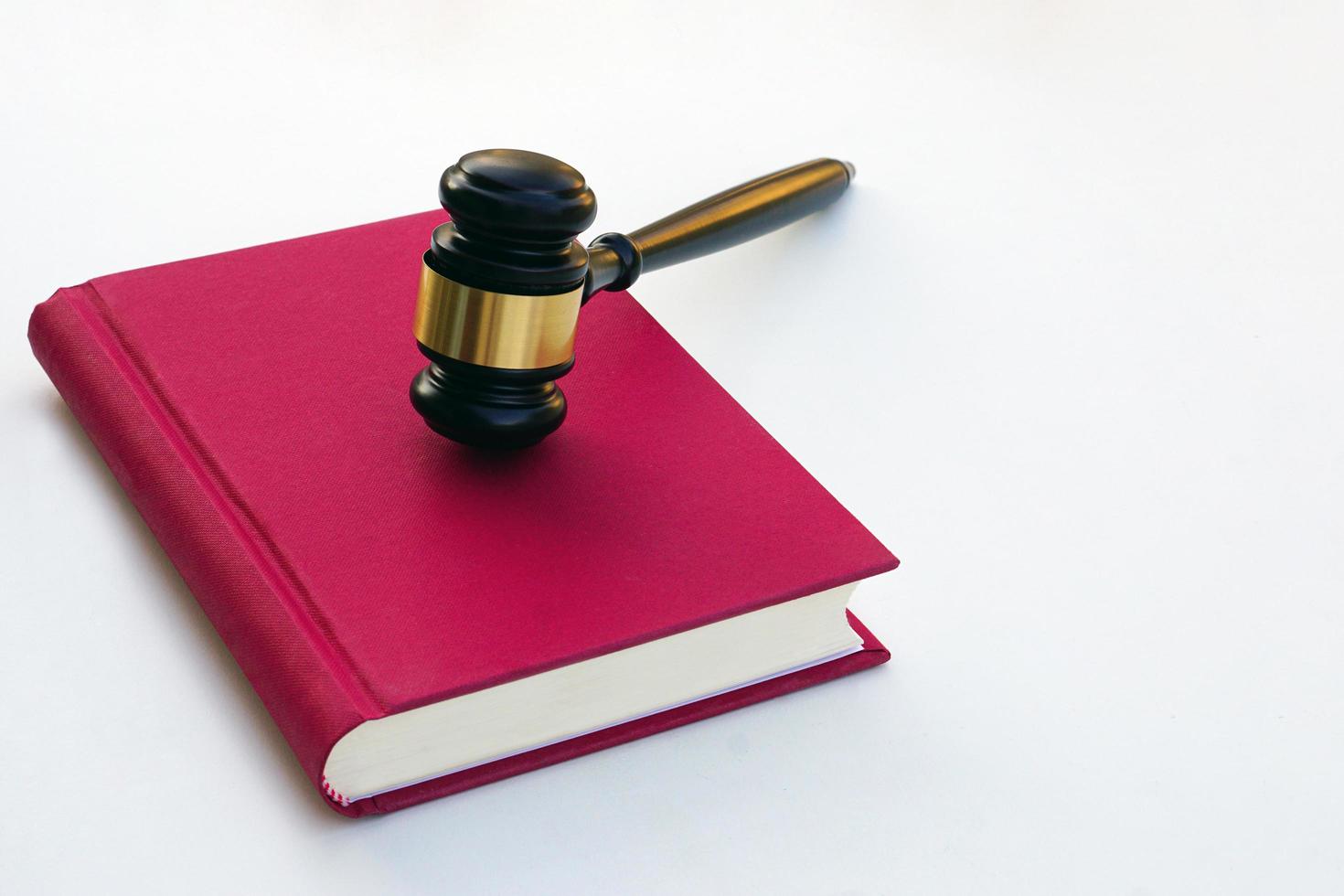 Close up of judge gavel, lawyer, law, justice placed on law book on white background. photo