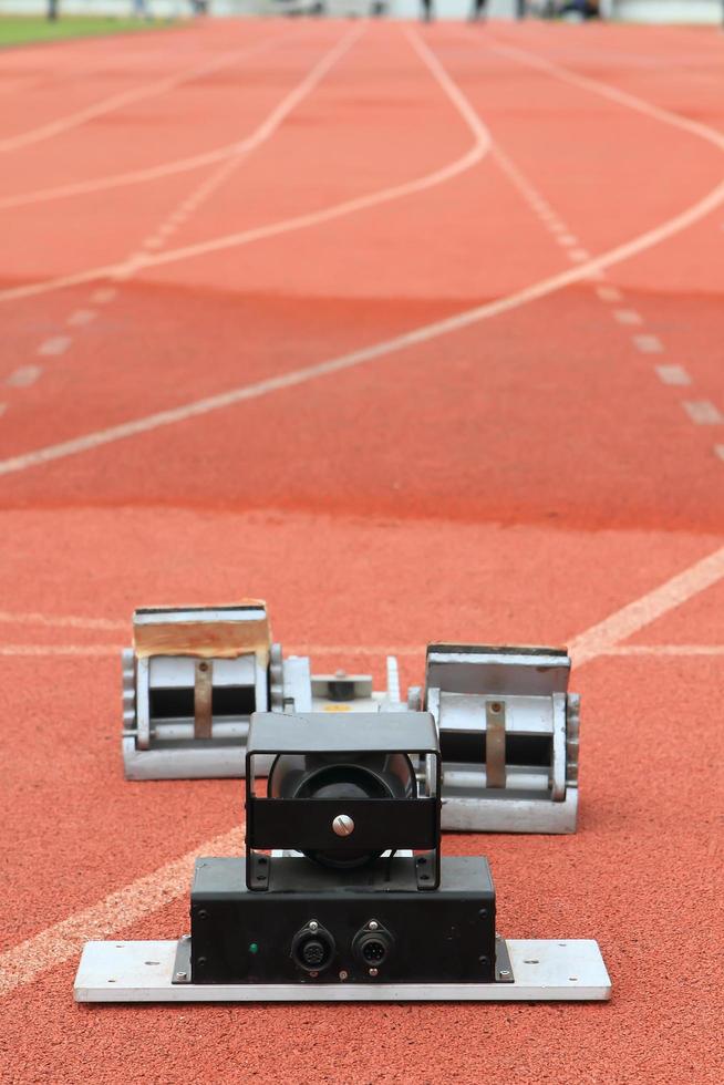 Bloques de salida de atletismo en una pista roja en un estadio foto