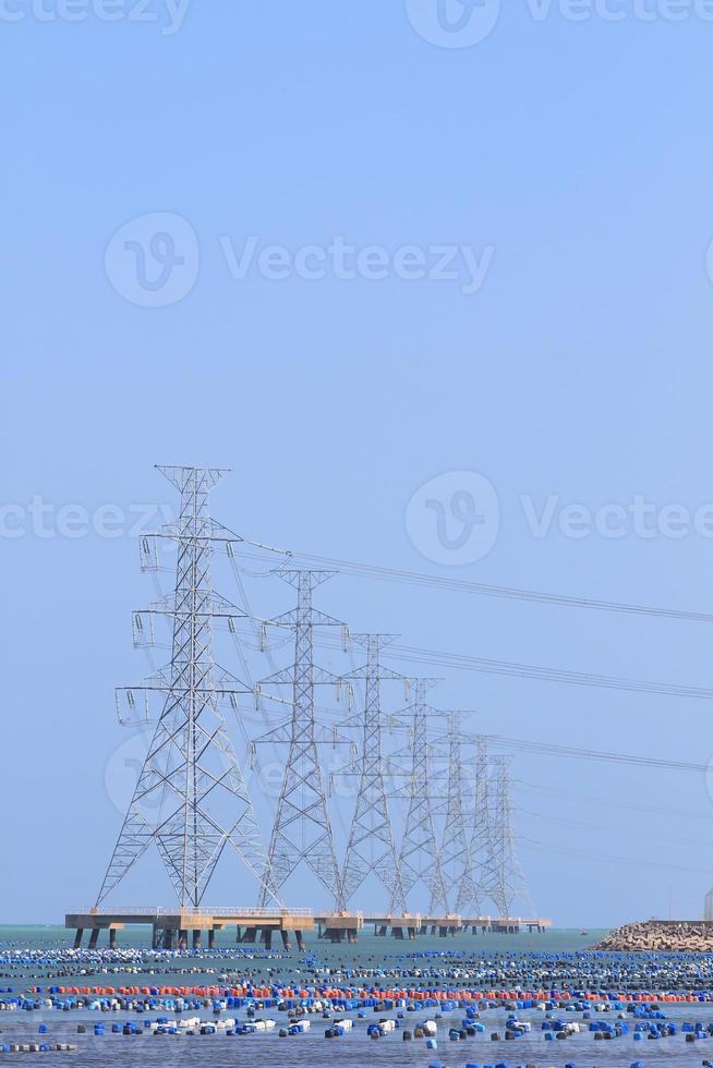 High voltage power pole in the sea photo