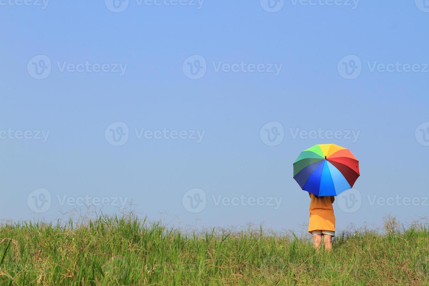 Beautiful woman holding multicolored umbrella and blue sky photo