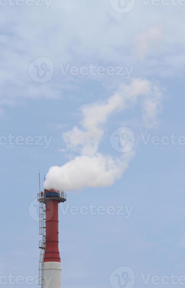 Plant pipe with smoke against blue sky photo
