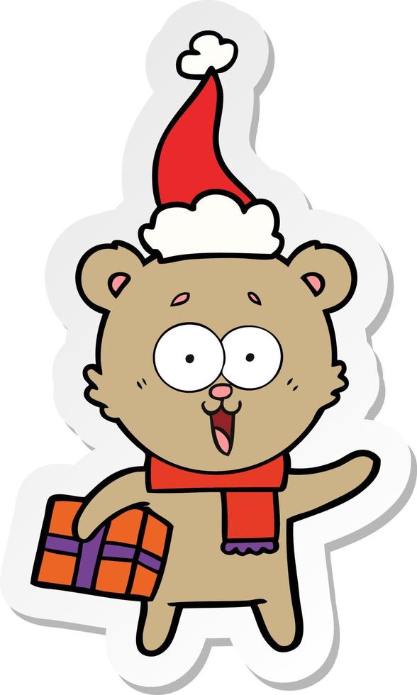 laughing teddy  bear with christmas present wearing santa hat vector