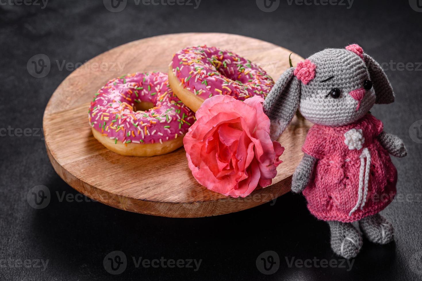 Beautiful knitted rabbit toy with doughnuts with pink glaze and coloured sprinkle photo
