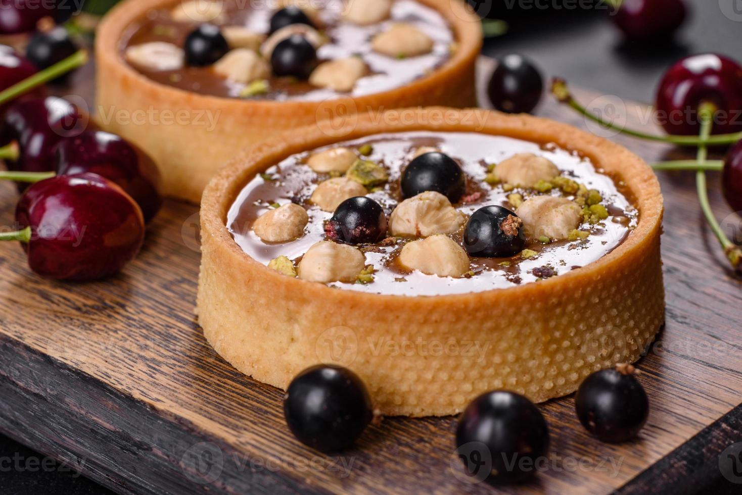 delicioso turrón fresco y tarta de nueces con bayas frescas en una tabla de cortar de madera foto