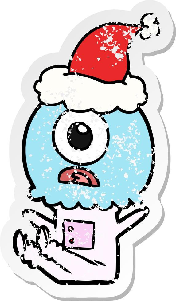 distressed sticker cartoon of a cyclops alien spaceman wearing santa hat vector