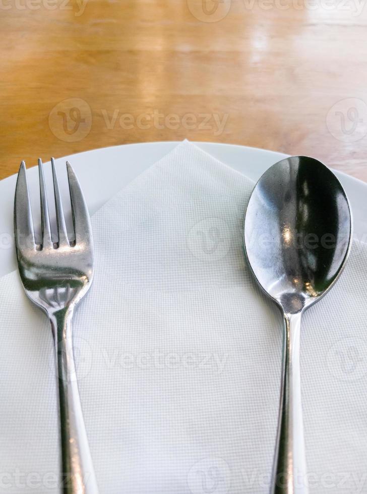 White plate with the silver spoon and fork. photo