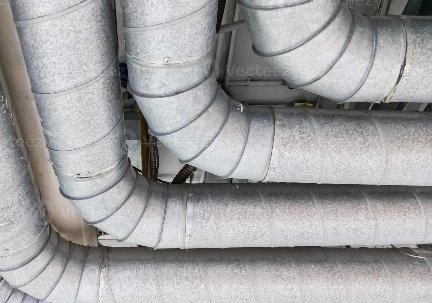 Metal pipe row is hanging along the ceiling. photo