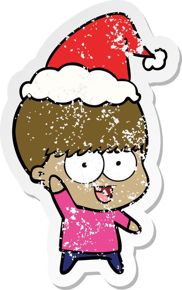 happy distressed sticker cartoon of a boy waving wearing santa hat vector