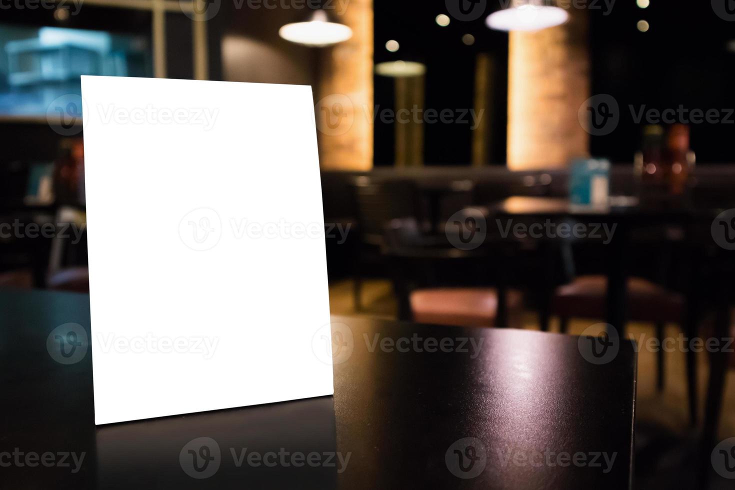 Mockup white label menu frame on table with cafe restaurant interior background photo